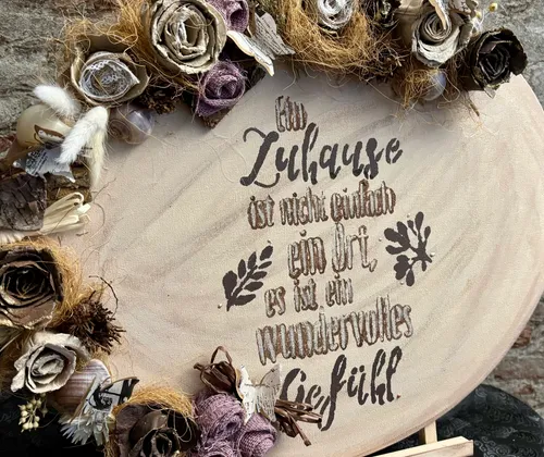 Decorative sign with floral surround, German text.