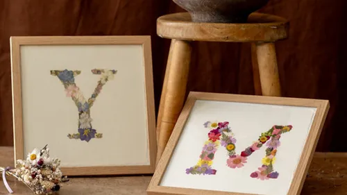 Florale Buchstaben Y und M in Rahmen.