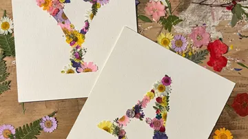Floral letters Y and A on wooden table.