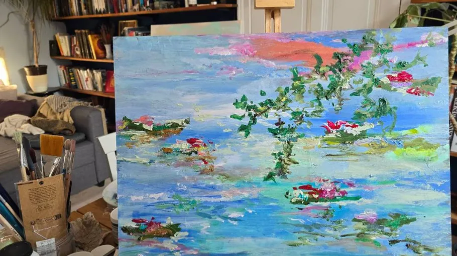 Colorful painting of water lilies on easel.