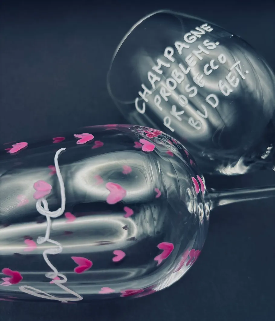 Two glasses decorated with text and hearts.