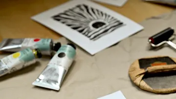 Art supplies and a black print on paper.