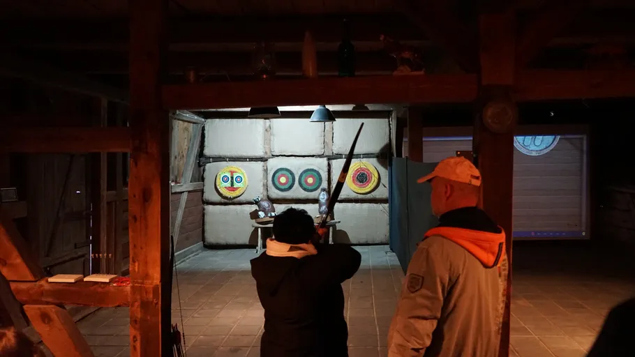 Menschen üben Bogenschießen in der Halle.