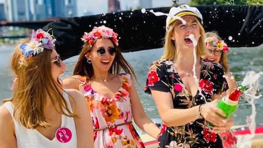 Frauen feiern mit Champagner auf einem Boot.