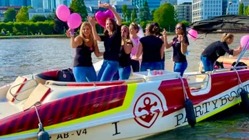 Frauen feiern auf einem Boot mit Ballons.