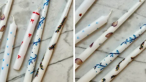 Decorative candles with unique designs on marble surface.