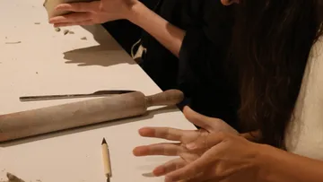 People crafting with clay at a table.