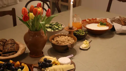 Table with food, flowers, and a candle.