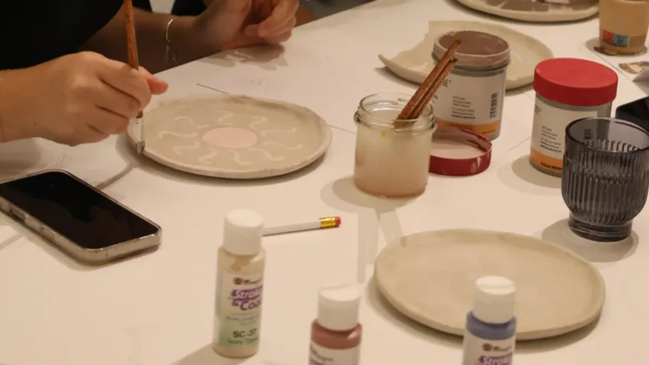 Person bemalt Keramikteller im Kunststudio.