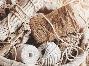 Wool and thread are scattered in a basket.