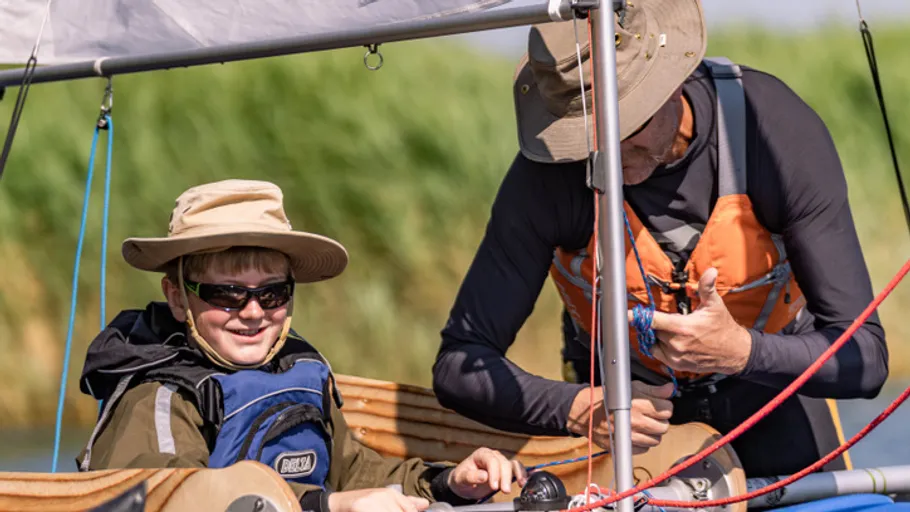 Two people sailing on a sunny day.