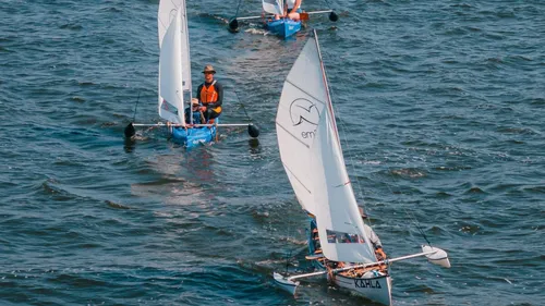 Three sailboats racing on open water.