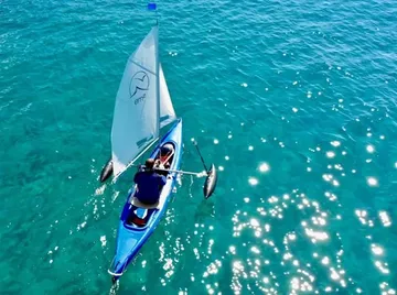 Kayak sailing on clear blue water.