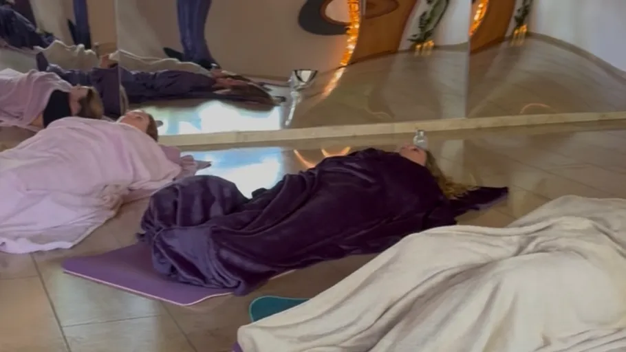 People resting on mats in a yoga studio.