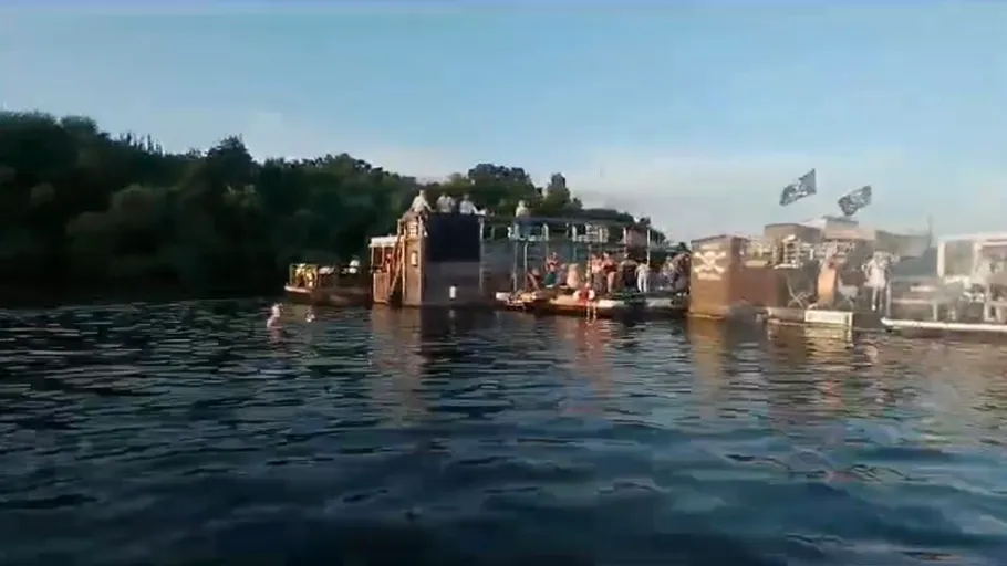 Menschen auf schwimmenden Plattformen auf einem See.