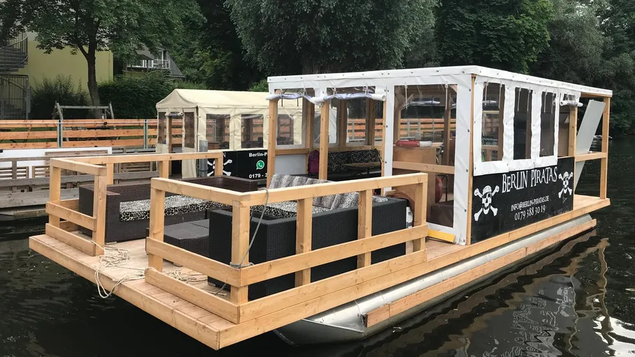 Holzpartyboot an einem Kanal angedockt.