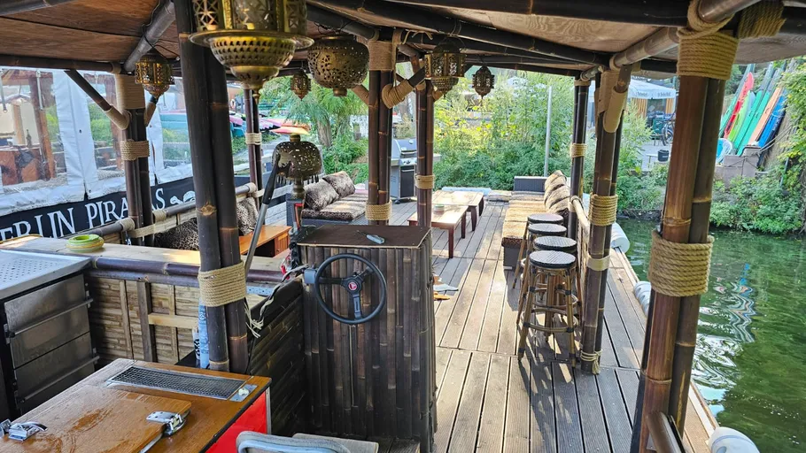 Boat interior with wooden furniture and lanterns.