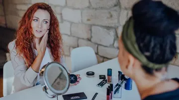 Zwei Frauen besprechen Make-up am Tisch.