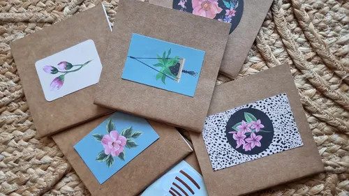 Grußkarten mit Blumenillustrationen auf geflochtener Oberfläche.