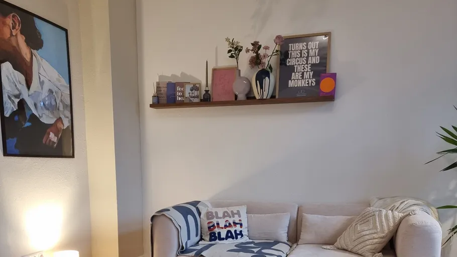 Cozy living room with decorated shelf and sofa.