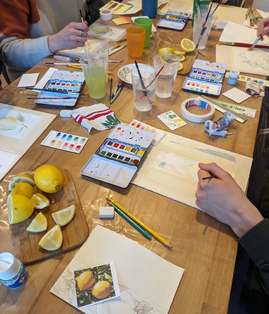 People painting at a table with lemons.