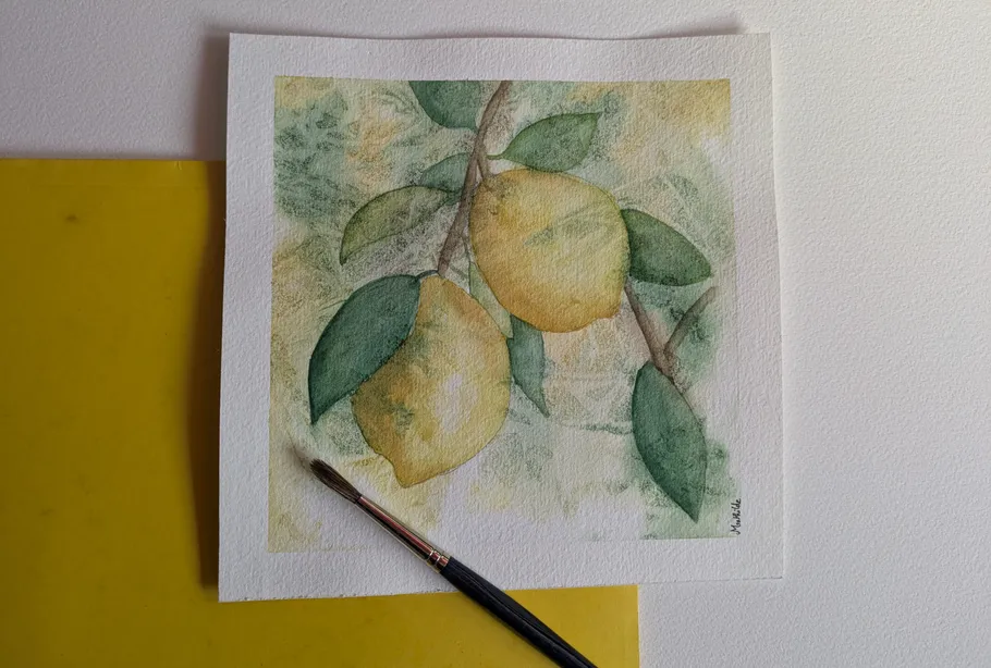 Zitronen-Aquarellbild mit Pinsel daneben.