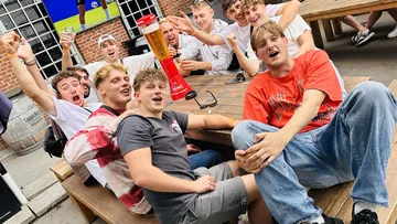 Group celebrating at outdoor table with drink tower.