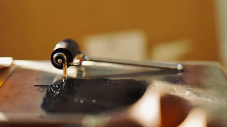 Rubber roller with ink on table.