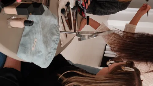 Women applying makeup at a table.