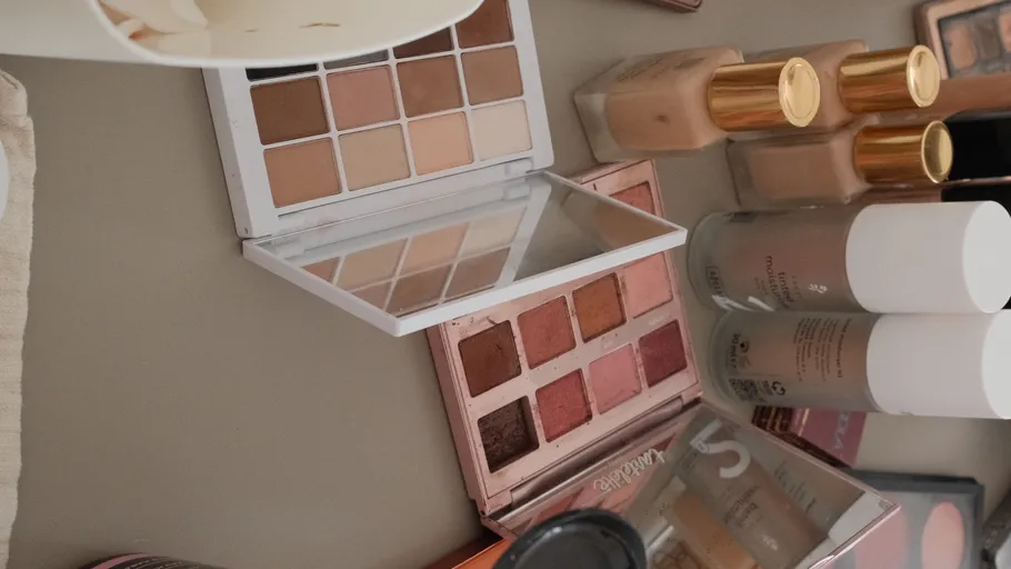 Make-up-Paletten und Flaschen auf einem Tisch.