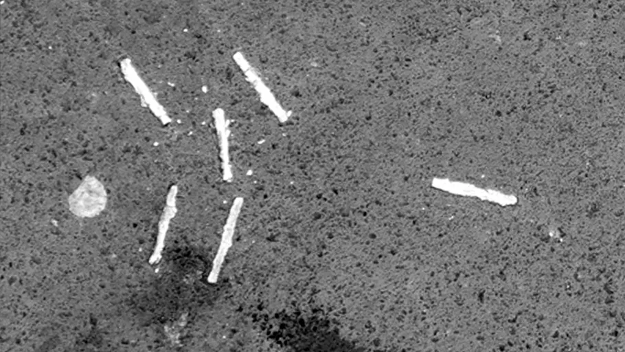 Weiße Linien verstreut auf grauem Pflaster.