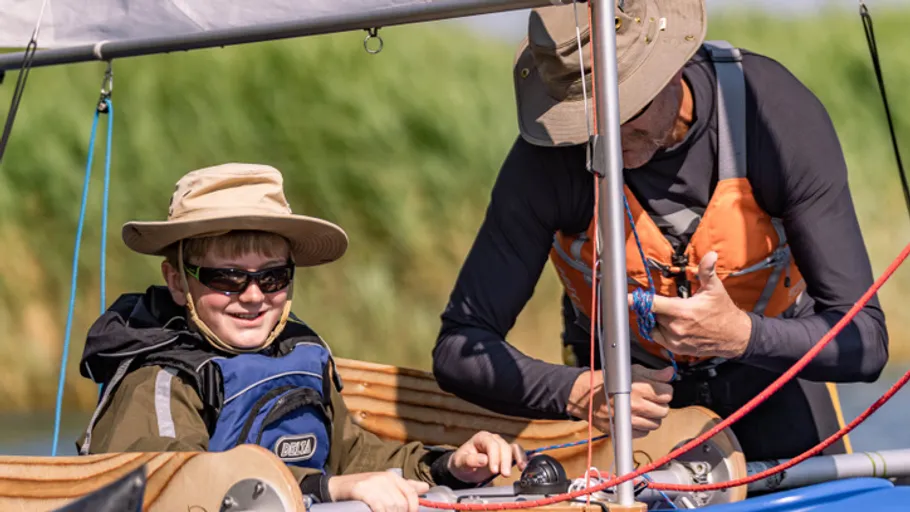 Two people sailing on a small boat.