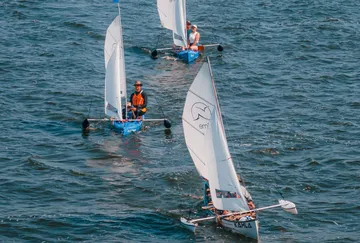 Three small sailboats navigating on water.