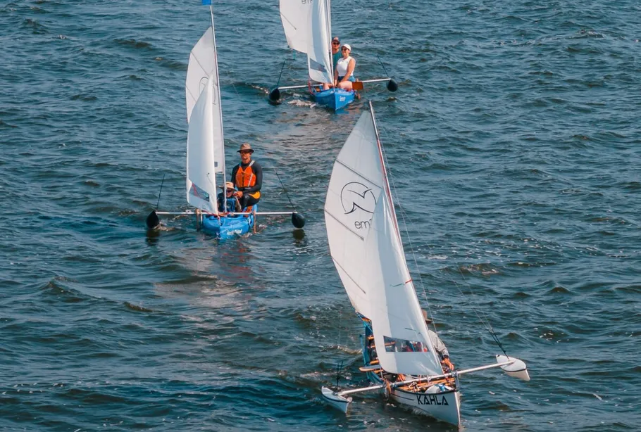 Three small sailboats navigating on water.