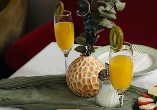 Drinks in glasses with kiwi garnish on table.