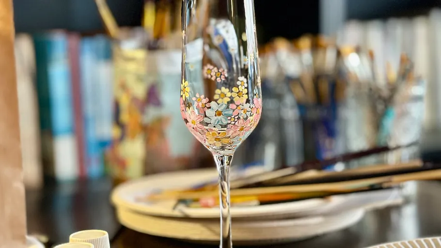 Dekoratives Glas mit Blumenmuster auf Tisch.