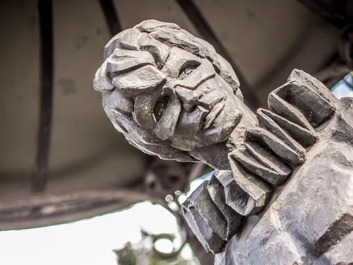 Sculpture depicting a portrait, outdoors under a pavilion.