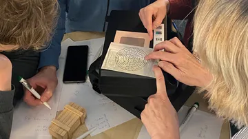 Personen lösen Rätsel auf einem Tisch.