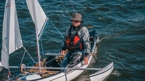 Person sailing small boat on water.