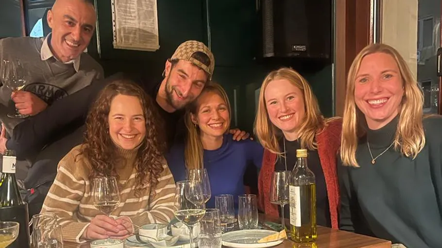 Group of people smiling at a dining table.