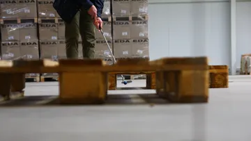 Person spielt Minigolf in Lagerhalle.