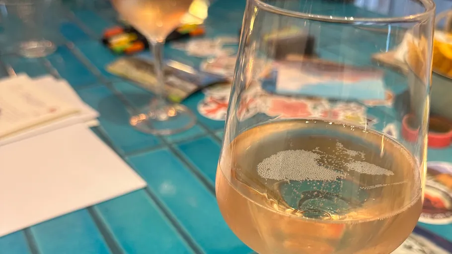 Glas Roséwein auf blauem Tisch.