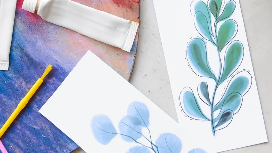 Painting supplies with two leaf sketches.