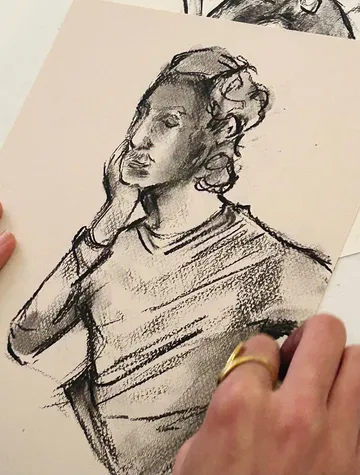Kohlezeichnung einer Person mit Hand am Gesicht.