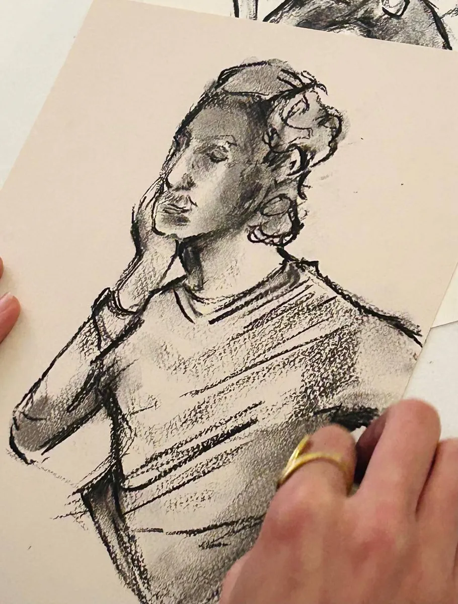 Charcoal drawing of person with hand on face.