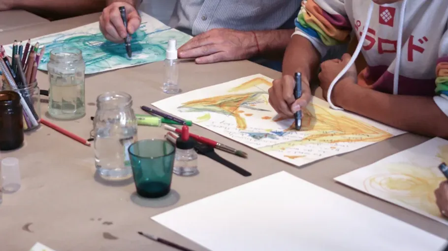 Menschen zeichnen Kunst an einem Tisch.