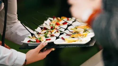Person serving appetizers on small plates.