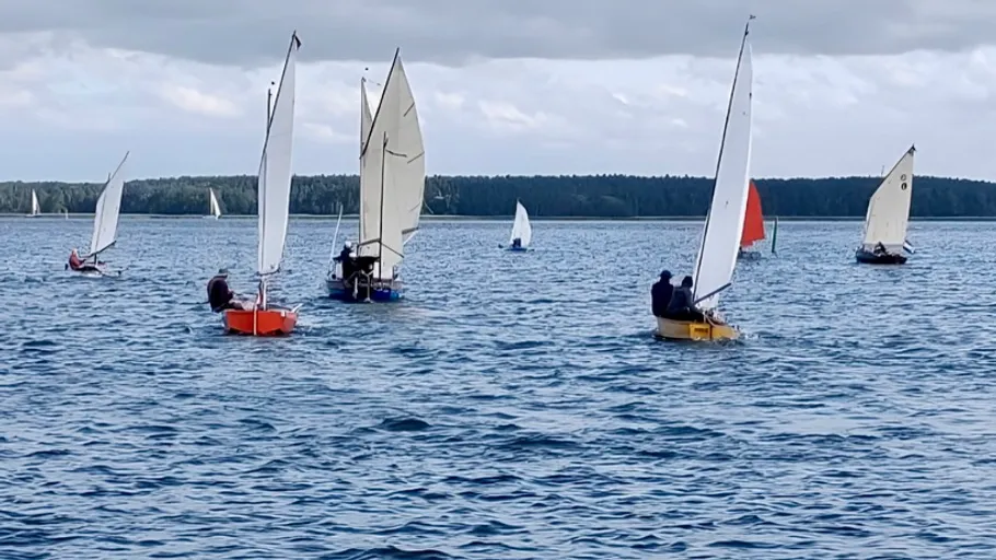 Segelboote bei einem Rennen auf ruhigem See.
