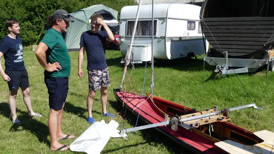 Men assembling boat outdoors at campsite.