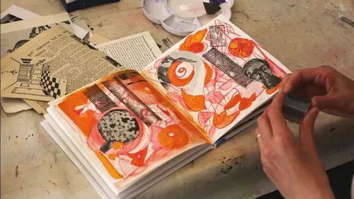 Hände arbeiten an Kunstjournal mit Collagen.